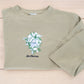 Embroidered wedding bouquet crewneck laid flat showing full design with custom name